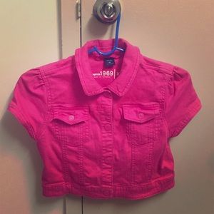 A pink, cropped, denim short sleeve jacket